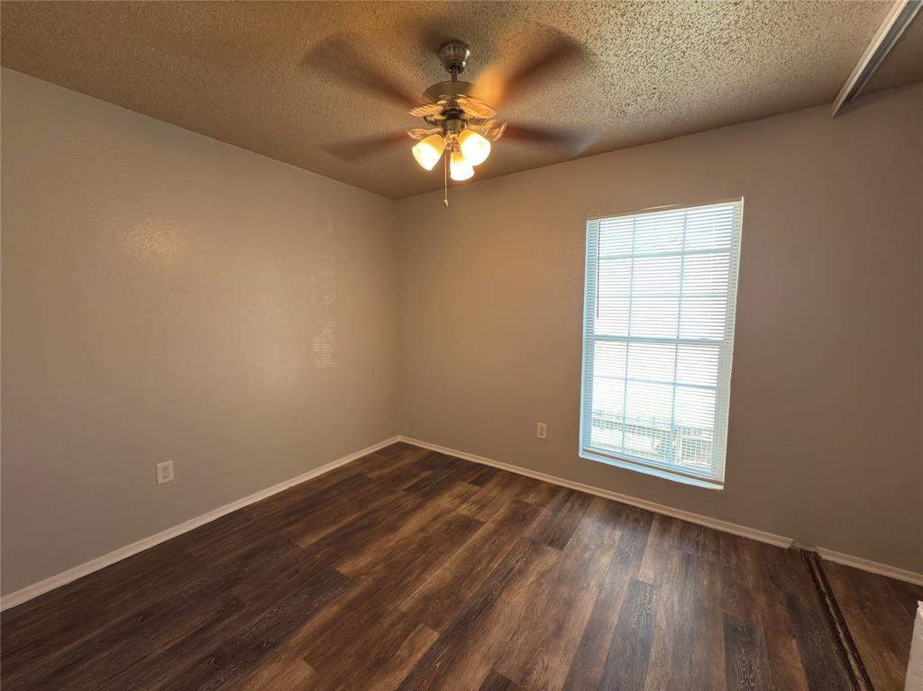 2250 Aspen Drive Dallas, TX 75227 - Photo 16 of 22 an empty room with wooden floor chandelier fan and windows
