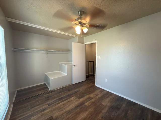 a view of a livingroom with wooden floor and a ceiling fan
