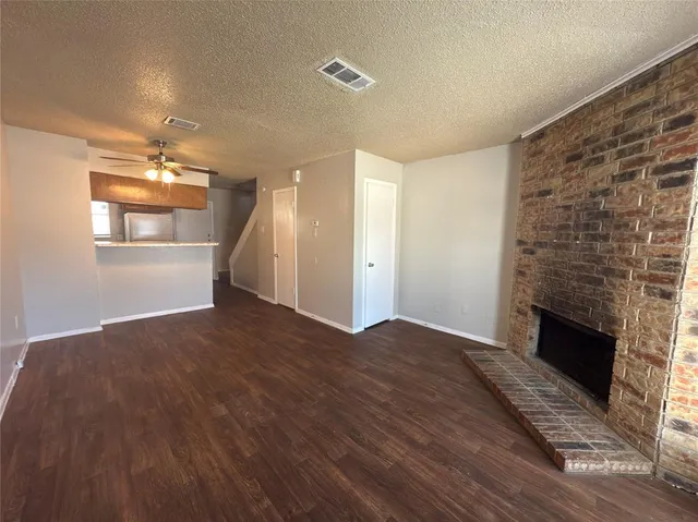 an empty room with windows and fireplace