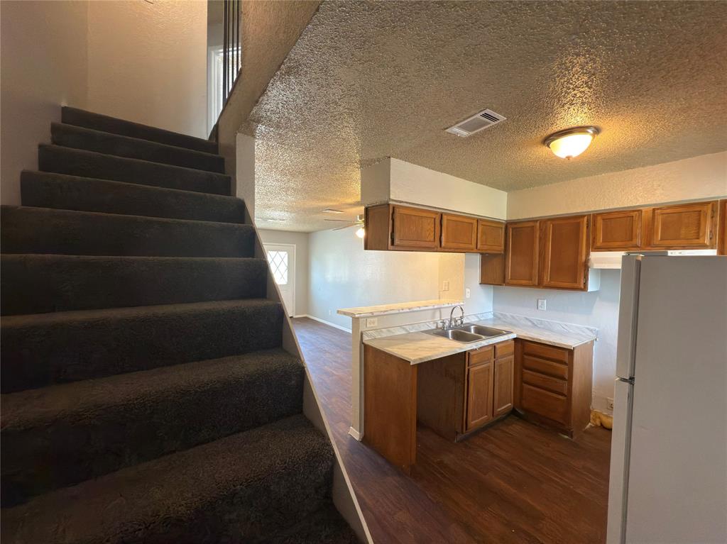 2250 Aspen Drive Dallas, TX 75227 - Photo 9 of 22 a kitchen with kitchen island a sink stove and refrigerator