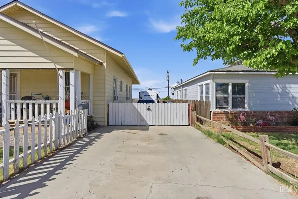 a backyard of a house with barbeque oven and trees