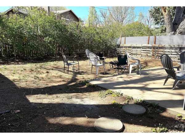 a view of a backyard with table and chairs and potted plants