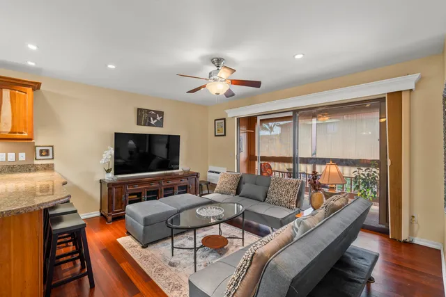 a living room with furniture flat screen tv and a large window