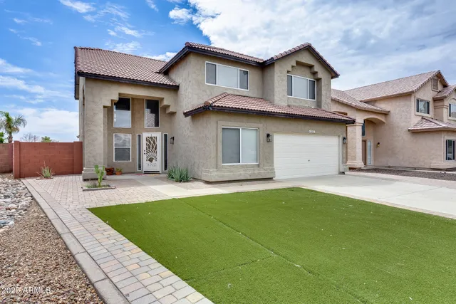 a front view of a house with a yard and garage