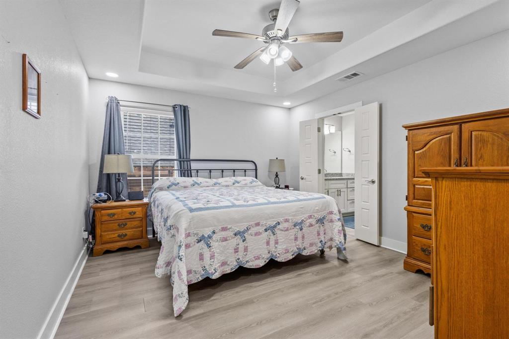608 East Shepherd Street Denison, TX 75021 - Photo 17 of 31 Spacious bedroom featuring wood-finish flooring, a tray ceiling, recessed lighting, and a ceiling fan