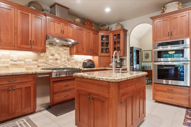 a kitchen with stainless steel appliances granite countertop a sink stove and refrigerator