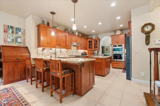 a kitchen with stainless steel appliances granite countertop a stove and cabinets