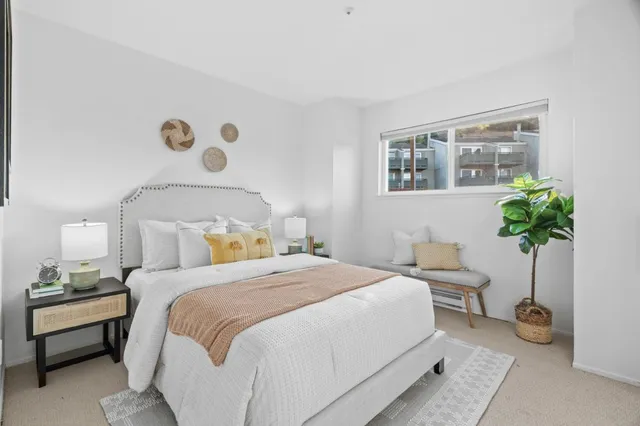 a bedroom with a bed and a potted plant