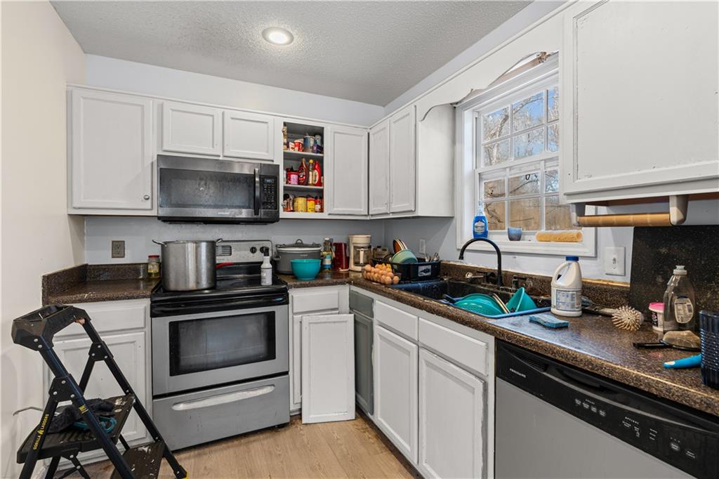 115 Cash Way Rockmart, GA 30153 - Photo 16 of 35 a kitchen with stainless steel appliances a stove a sink a microwave and cabinets