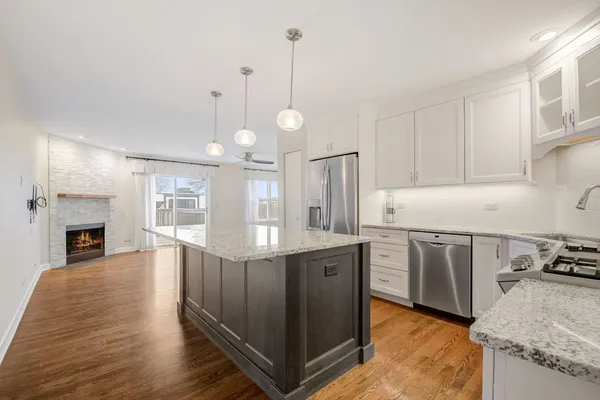 a kitchen with stainless steel appliances granite countertop a stove refrigerator and cabinets