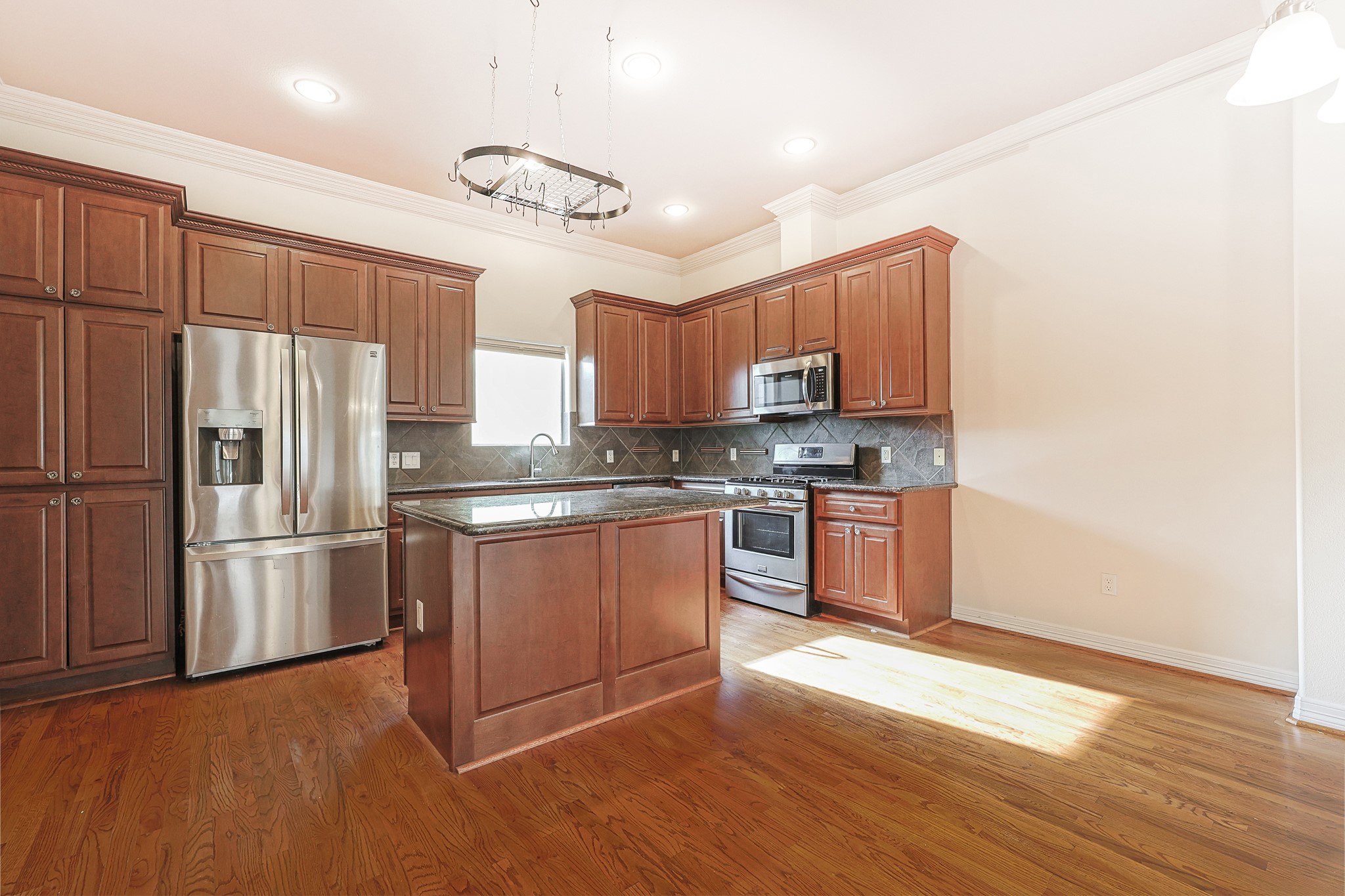 2540 Prospect Street, Unit C Houston, TX 77004 - Photo 9 of 31 a kitchen with granite countertop a refrigerator stove and wooden floor