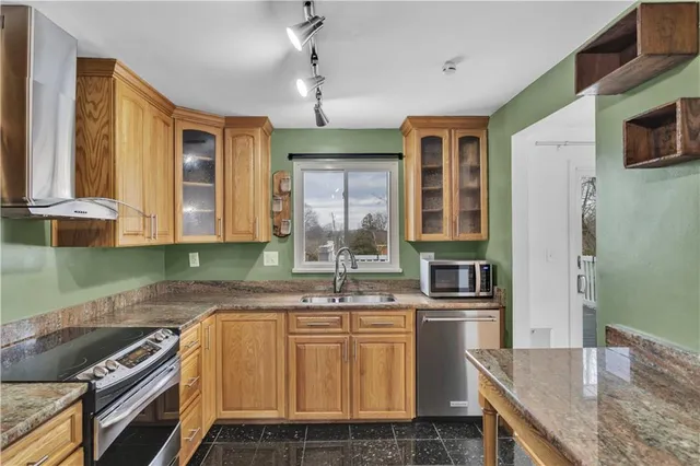 a kitchen with stainless steel appliances granite countertop a sink stove and refrigerator
