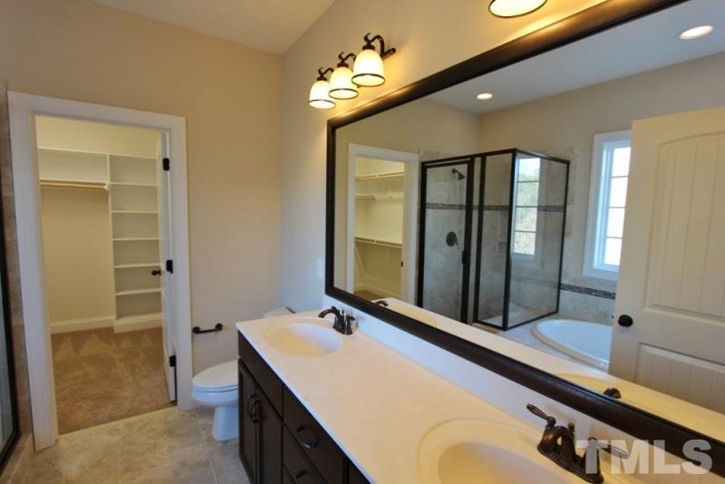 201 Virginia Water Drive Rolesville, NC 27571 - Photo 11 of 25 a bathroom with a granite countertop sink and a mirror