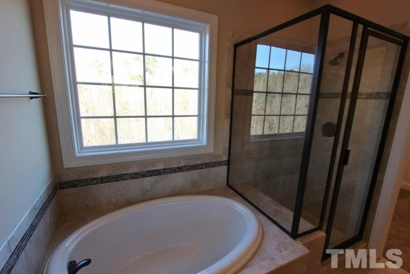 201 Virginia Water Drive Rolesville, NC 27571 - Photo 12 of 25 a bath tub sitting in a bathroom next to a window