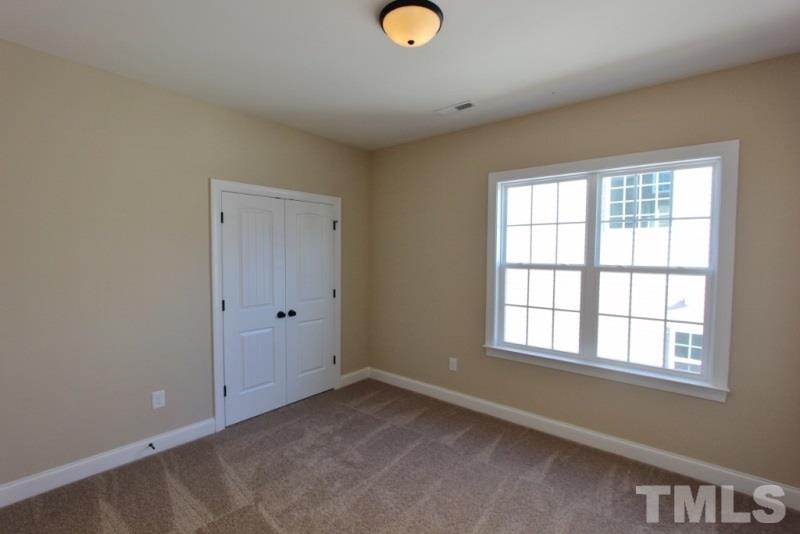 201 Virginia Water Drive Rolesville, NC 27571 - Photo 14 of 25 an empty room with wooden floor and windows