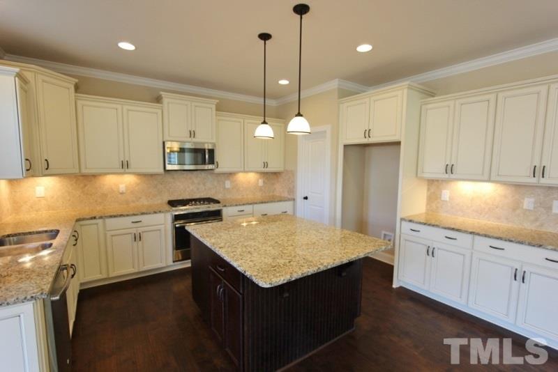 201 Virginia Water Drive Rolesville, NC 27571 - Photo 3 of 25 a kitchen with kitchen island granite countertop a sink a center island and stainless steel appliances