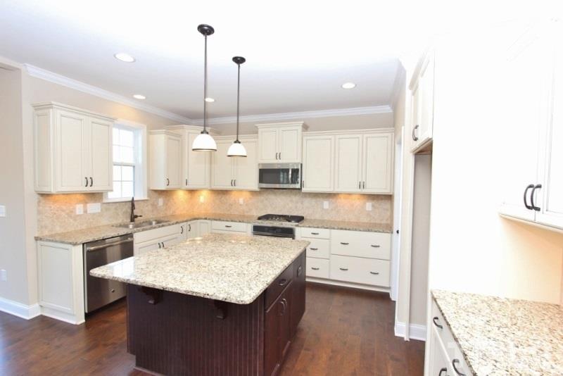 201 Virginia Water Drive Rolesville, NC 27571 - Photo 4 of 25 a kitchen with a stove a sink a refrigerator and a coffee table