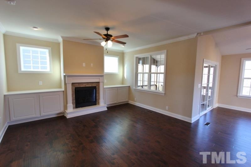 201 Virginia Water Drive Rolesville, NC 27571 - Photo 5 of 25 a view of a livingroom with a fireplace wooden floor and windows