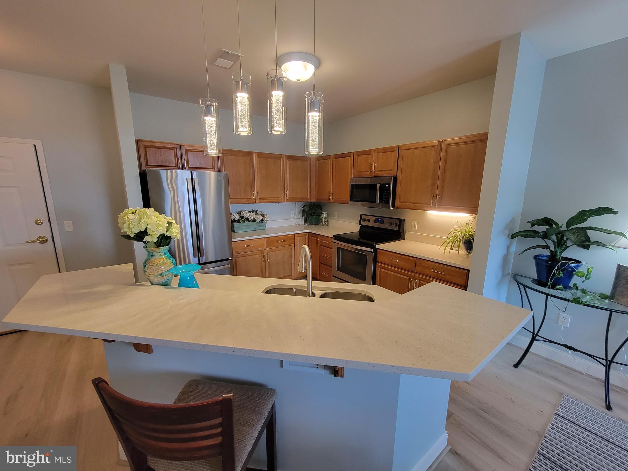 1000 Fountainview Circle, Unit 1413 Newark, DE 19713 - Photo 1 of 17 a kitchen with granite countertop a table chairs stove and refrigerator