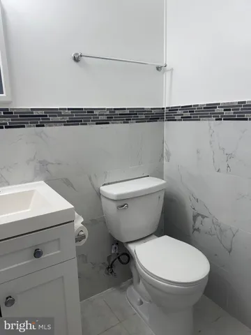 a bathroom with a toilet a sink and a mirror