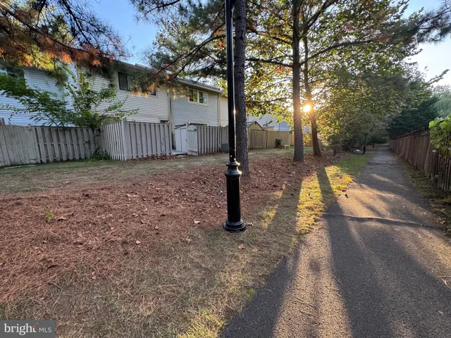 a view of a yard with wooden fence