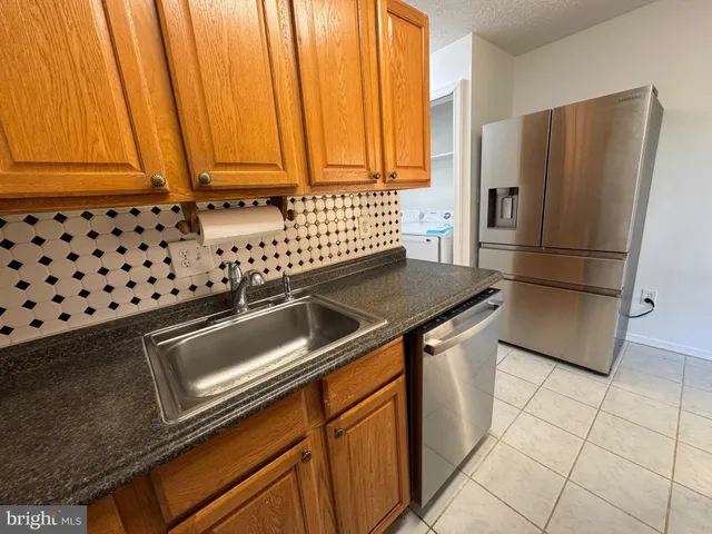 a kitchen with stainless steel appliances a refrigerator a sink and a stove