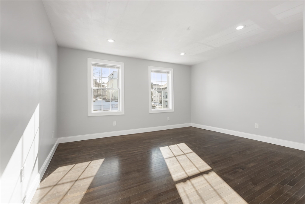 222 Rock Street, Unit 2 Fall River, MA 02720 - Photo 14 of 21 an empty room with wooden floor and windows