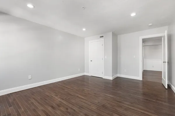 a view of an empty room with wooden floor