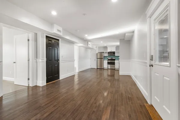 a view of a kitchen with a refrigerator wooden floor and a kitchen