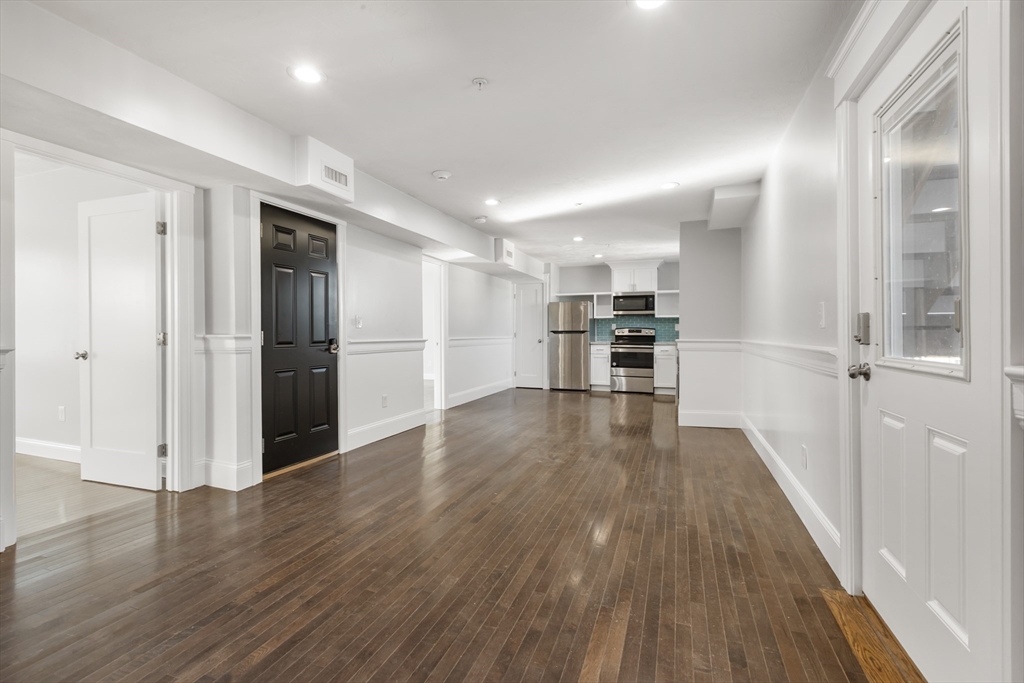 222 Rock Street, Unit 2 Fall River, MA 02720 - Photo 2 of 21 a view of a kitchen with a refrigerator wooden floor and a kitchen