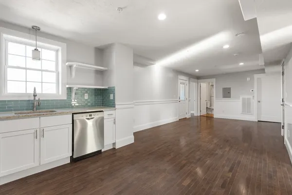 a kitchen with granite countertop a stove a sink and a refrigerator
