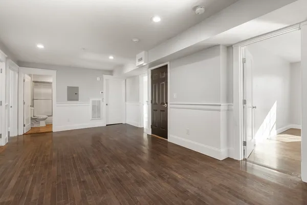 a view of empty room with wooden floor and window