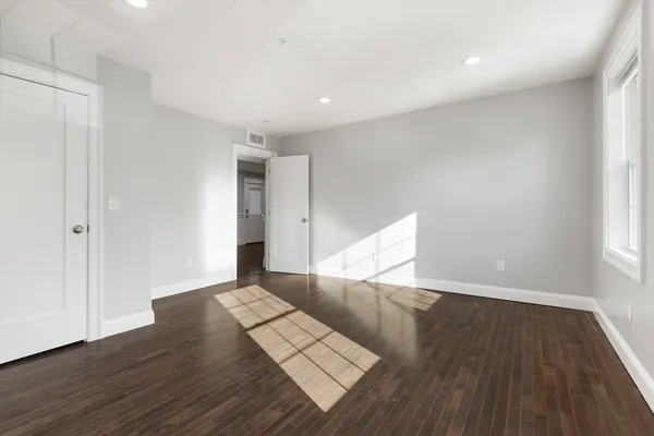 a view of an empty room with wooden floor