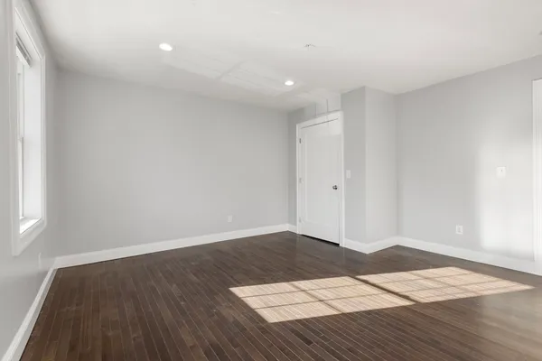 a view of an empty room with wooden floor