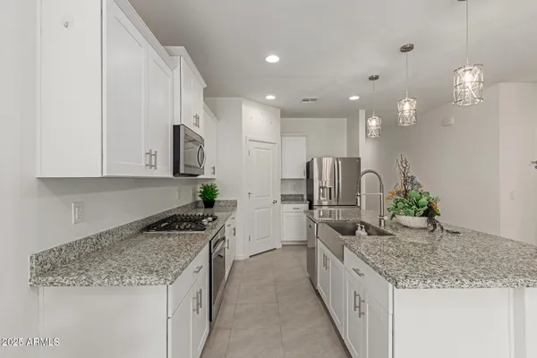 a kitchen with kitchen island granite countertop a sink and refrigerator