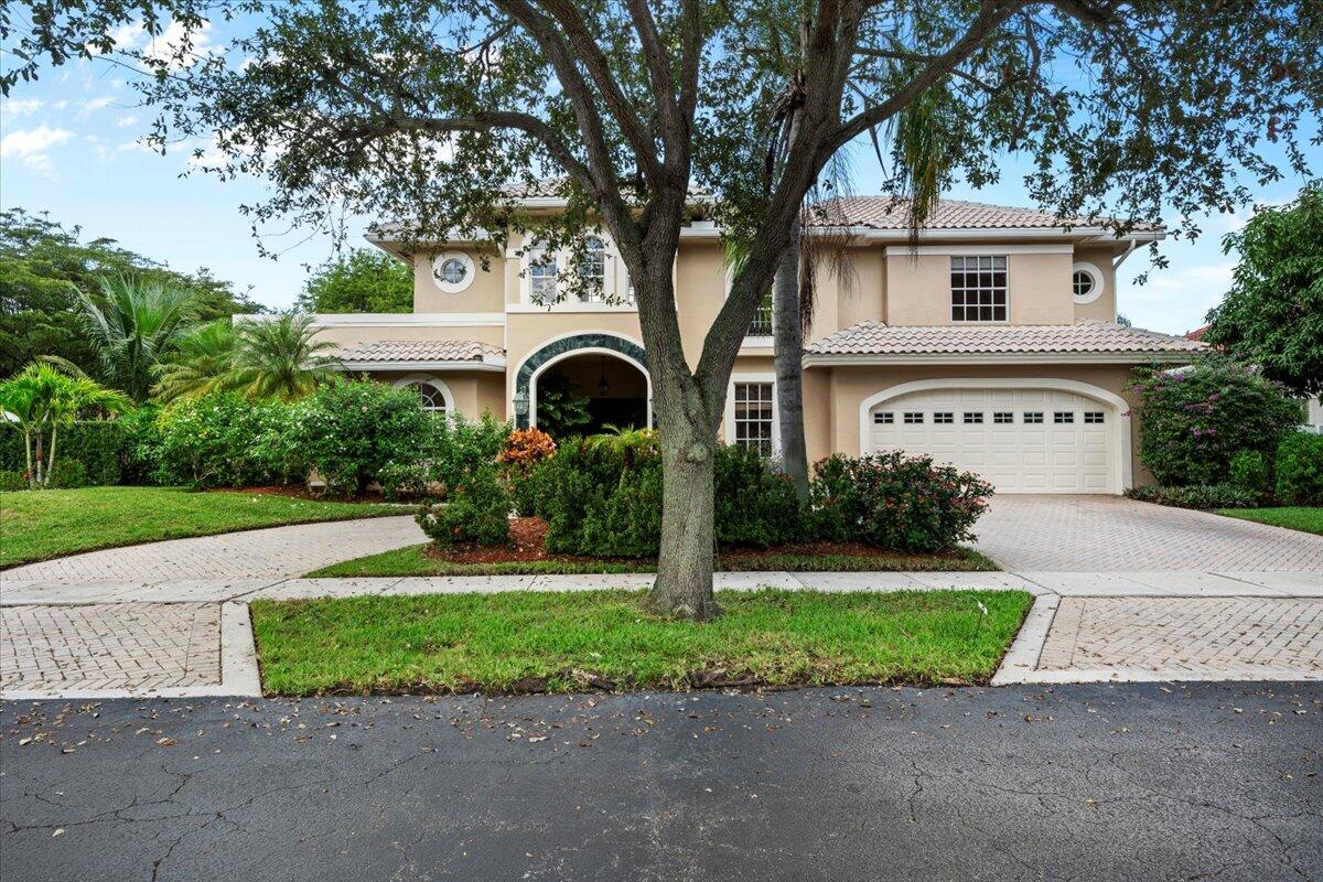 3241 Northwest 63rd Street Boca Raton, FL 33496 - Photo 4 of 75 a front view of a house with a yard and garage