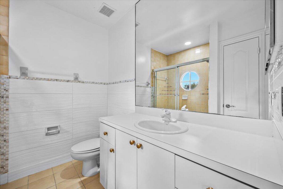 3241 Northwest 63rd Street Boca Raton, FL 33496 - Photo 48 of 75 a bathroom with a granite countertop sink a toilet and a mirror