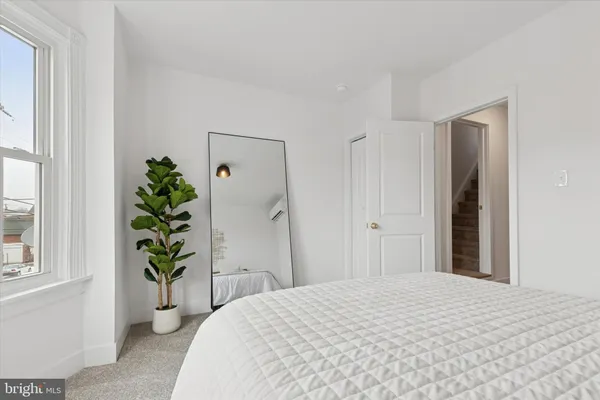 a bedroom with a bed and a potted plant