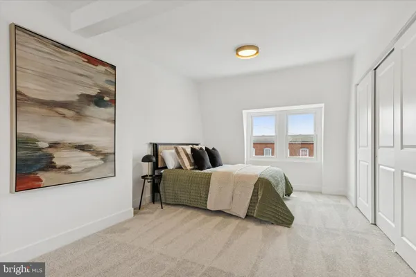 a bedroom with a bed and painting on the wall