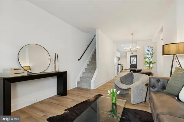 a living room with furniture a mirror and a chandelier