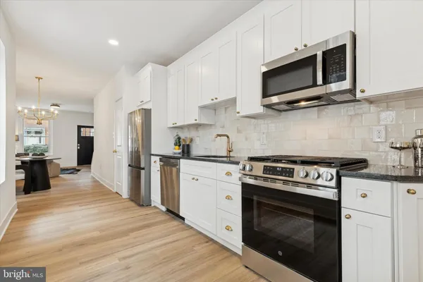 a kitchen with stainless steel appliances a stove microwave and refrigerator