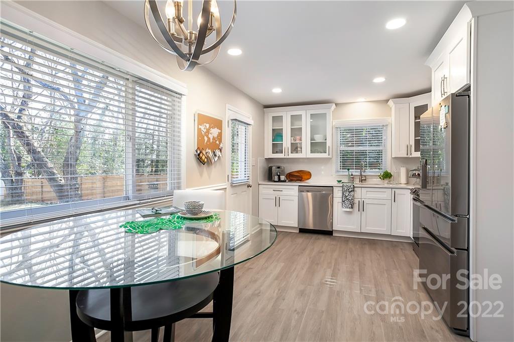 6009 Pepperhill Road Charlotte, NC 28212 - Photo 6 of 17 a kitchen with stainless steel appliances granite countertop a stove a sink a refrigerator and a dining table with wooden floor