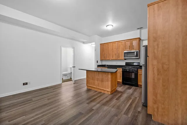 a kitchen with wooden floors and appliances