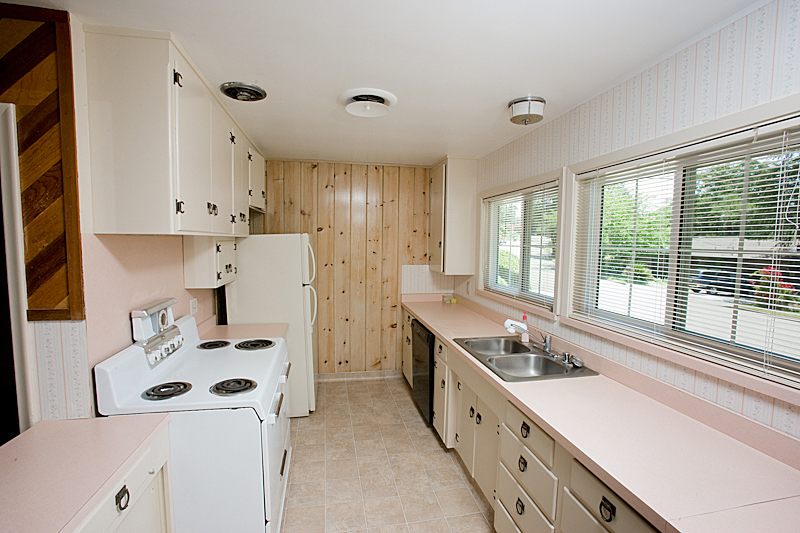 1710 Barbara Road Redding, CA 96003 - Photo 8 of 23 a kitchen with a sink a stove and white cabinets with wooden floor