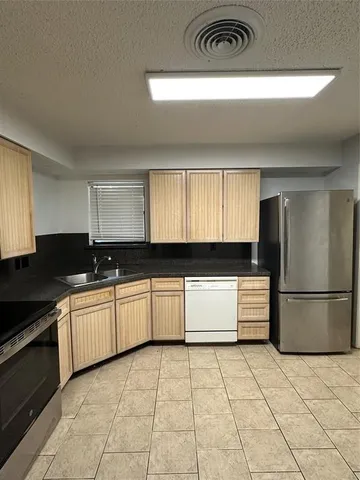 a kitchen with a sink a stove and cabinets
