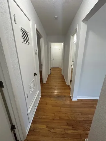 a view of a hallway with wooden floor and staircase