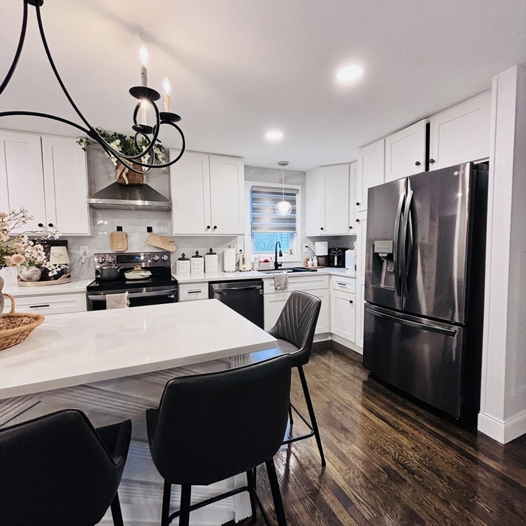 20 Morgan Road Holbrook, MA 02343 - Photo 8 of 21 a kitchen with stainless steel appliances a white refrigerator a sink a stove a dining table and chairs with wooden floor