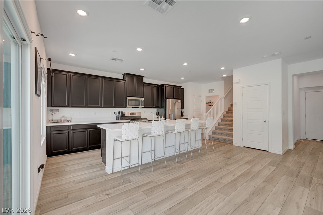 7204 North Decatur Boulevard, Unit 3 North Las Vegas, NV 89084 - Photo 11 of 48 A well-lit kitchen with dark cabinetry, integrated appliances, and an inviting island with seating.