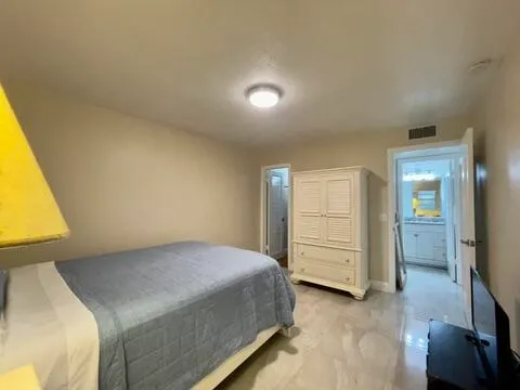 a bathroom with a granite countertop sink a toilet and a large mirror