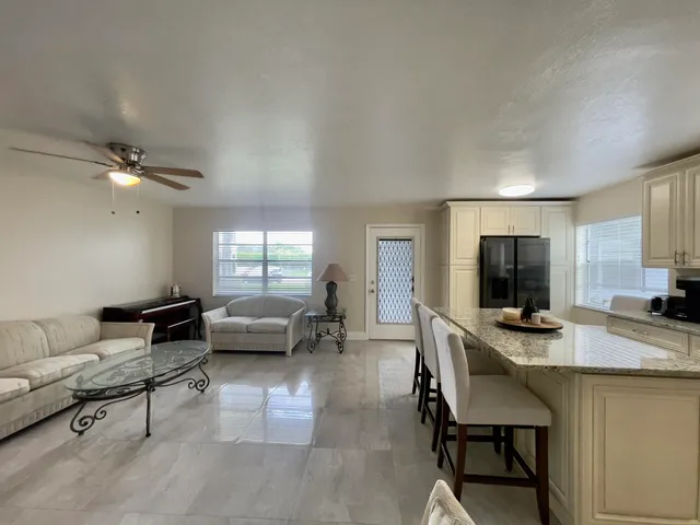 a living room with furniture a dining table and a window
